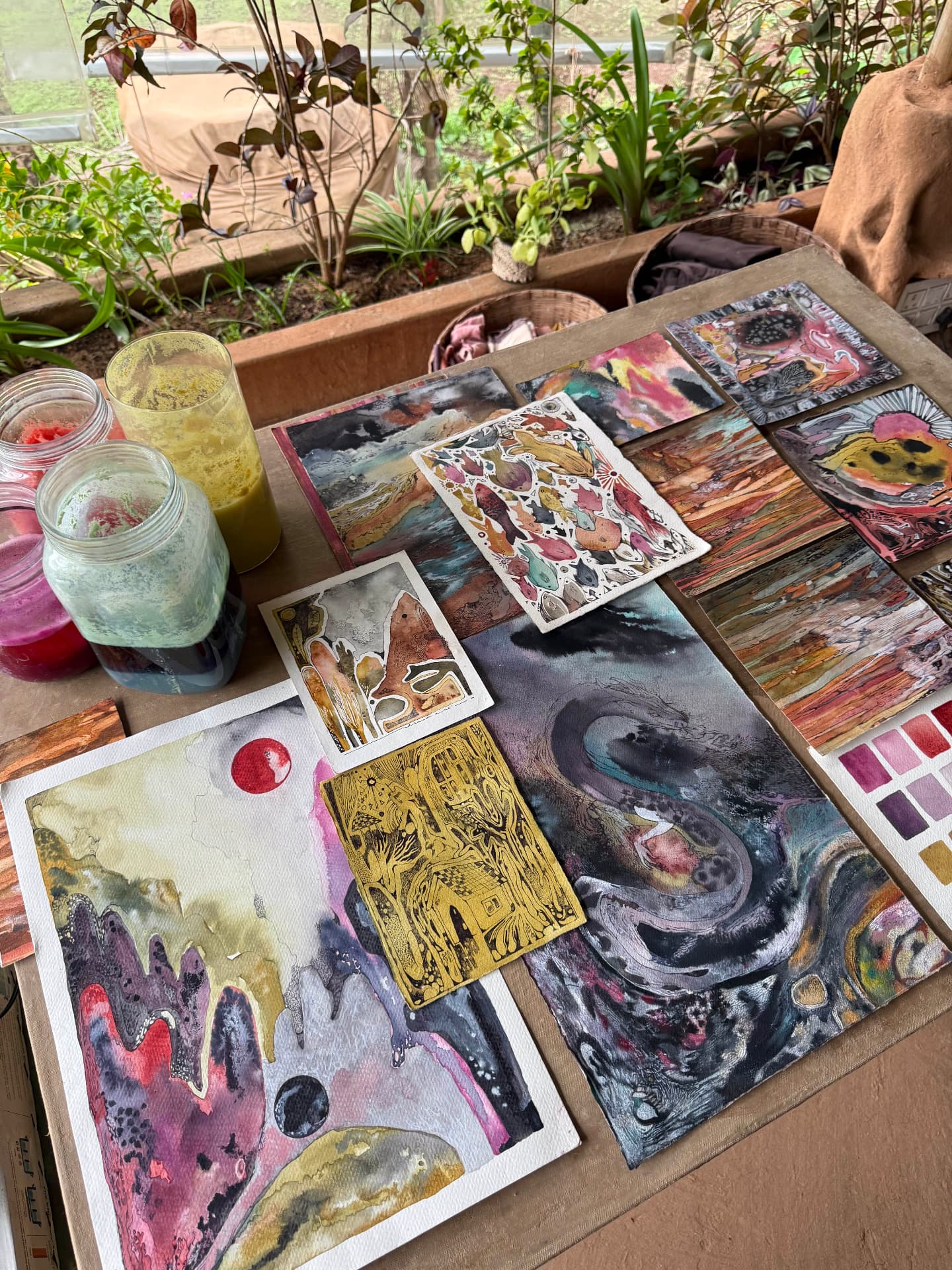 Paintings made with natural pigments laid out on a studio table